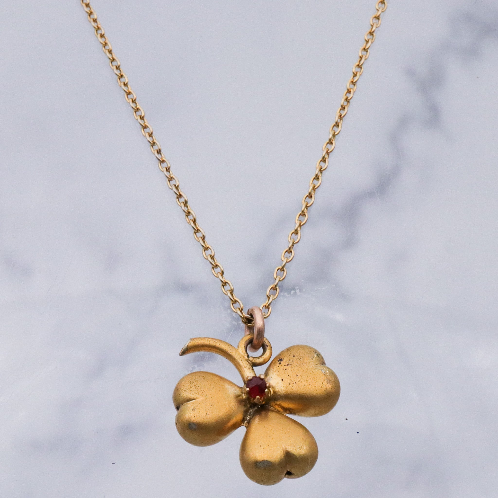 Antique Victorian gilt metal clover with faux garnet pendant